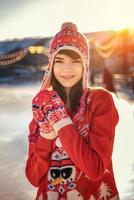 retrato de una mujer joven en la pista de hielo, una sonrisa en su rostro, el sol foto