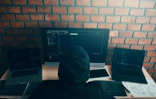 hacker en el capó trabajando con una computadora con piratería irrumpiendo en servidores de datos. foto