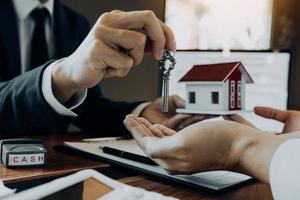 Home agents are handing out keys to home buyers who are signing contracts at the office. photo