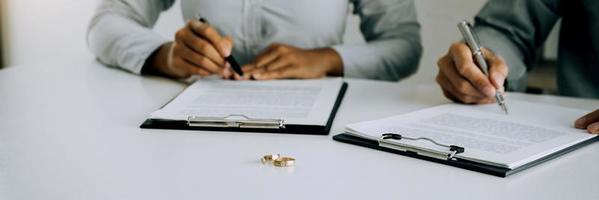 Husband and wife crate signing divorce documents at lawyer office. photo