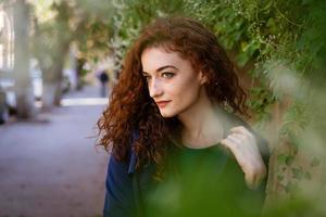 hermosa mujer joven con cabello rojo y pecas en el fondo de la pared foto