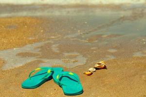 blue Slippers stand on the sand on the seashore photo