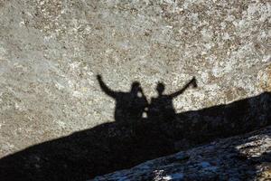 Shadow of a group of people on a rock photo