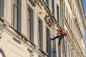 cleaning the facade of the building during the day photo