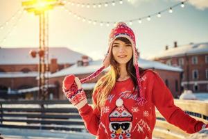 beautiful young woman on the ice rink, smiling in the sun photo