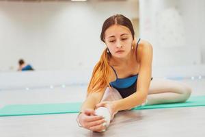 the girl is engaged in gymnastics , doing stretching in the gym photo