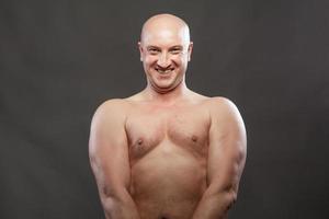 A man with a naked torso shows muscles in the background photo