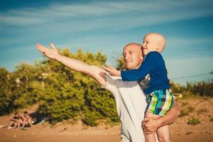 happy father and son walking on the beach photo