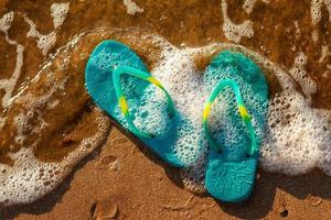 blue sandals on the beach , the concept of rest on the sea photo
