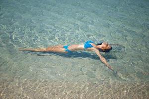 beautiful woman in turquoise sea in swimsuit, vacation concept photo