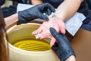 hand care with hot wax, covering with wax, manicure salon photo