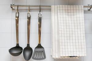 utensilios de cocina colgados en la pared y toalla foto