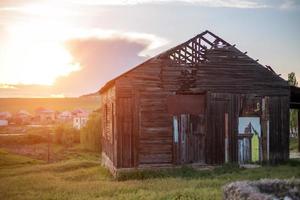 old abandoned wooden house is on the end of the day photo