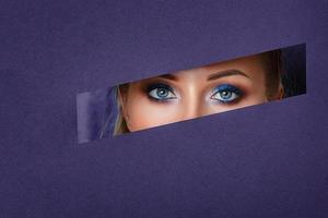 beautiful women's eyes look in the paper hole, bright make-up ,