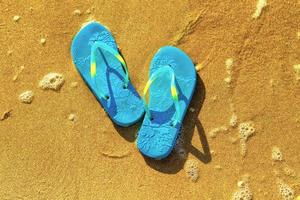 blue sandals on the beach , the concept of rest on the sea photo