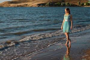 cute girl walking on the beach in summer photo