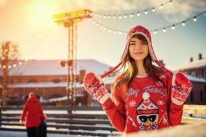beautiful young woman on the ice rink, smiling in the sun photo