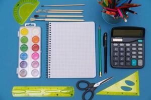 School supplies lying on a blue background. photo