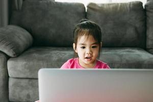 los estudiantes de jardín de infantes están aprendiendo en línea con maestros y amigos chateando en video en una computadora mientras la escuela está cerrada mientras se propaga el virus. foto