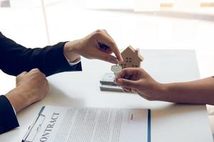 New home buyers are signing a home purchase contract at the agent's desk. photo