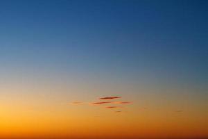 hermosas nubes de puesta de sol en el cielo sobre el mar, colores brillantes de puesta de sol foto