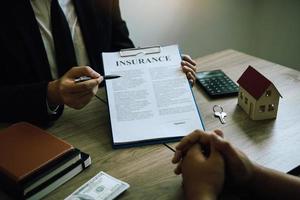 Agents are using pens pointing to insurance contracts and are being explained to customers at the office. photo