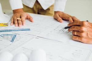 dos arquitectos o ingenieros asociados trabajando con planos y discutiendo proyectos juntos en la reunión en la oficina. foto