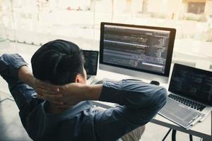 Asian programmers man are relaxing and looking at the code on the computer screen in the office. photo