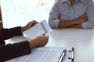 Male employee handed out a resignation envelope to the manager. photo