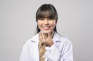 Young female dentist holding invisalign braces over white background studio, dental healthcare and Orthodontic concept. photo