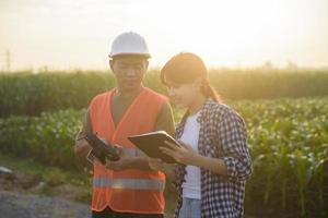 el ingeniero masculino brinda una consulta e instrucción a un agricultor inteligente con fertilizantes y pesticidas rociados con drones sobre tierras de cultivo, innovaciones de alta tecnología y agricultura inteligente foto