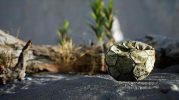 An old torn soccer ball thrown lies on sand of sea beach video