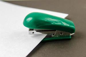 green stapler with wthite paper photo