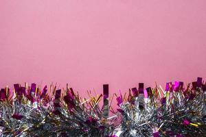 pink background with christmas tinsel photo