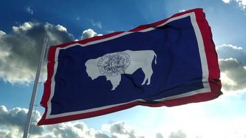 bandera de wyoming en un asta de bandera ondeando en el viento, fondo de cielo azul. representación 3d foto