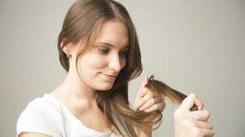 girl on a gray background holds a hair in her hand photo