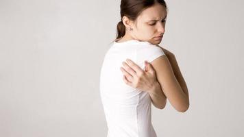 Attractive teenage girl suffers from backache. All on white background photo