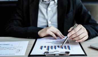 Accounting businessmen are calculating income-expenditure and analyzing real estate investment data, Dedicated to the progress and growth of the company, Financial and tax systems concept. photo
