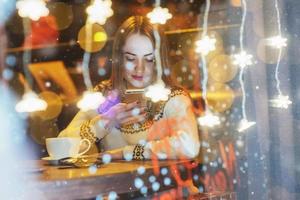 Young beautiful woman sitting in cafe, drinking coffee. Christmas, new year, Valentines day, winter holidays concept photo