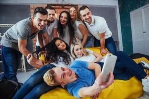 agrupar a hermosos jóvenes haciendo selfie en un café, mejores amigos niñas y niños juntos divirtiéndose, planteando un concepto de estilo de vida emocional foto