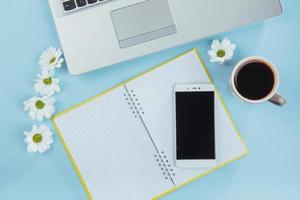 On the blue background notebook pencil, ruler and white flowers photo