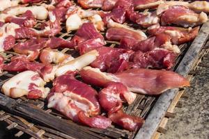 Preserving pork meat by dry with Sun-dried on bamboo basket weave palat. photo