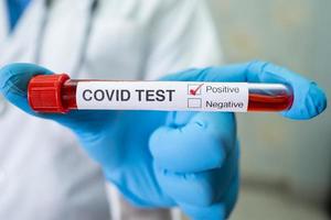 Positive blood infection sample in test tube for covid-19 coronavirus in lab. Scientist holding to check and analyze for patient in hospital. photo