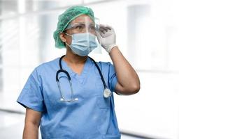 médico asiático con protector facial y traje de ppe nuevo normal para comprobar que el paciente protege la seguridad infección brote de coronavirus covid-19 en la sala de cuarentena del hospital de enfermería. foto