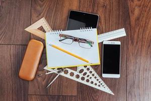 Top view of notebook, stationery, drawing tools and a few glasses. improvise. photo