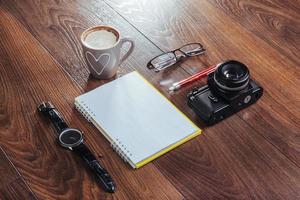 reloj, cámara y portátil en un fondo marrón foto