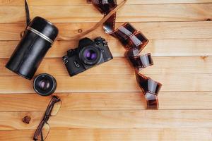 Old film camera and a roll of on wood photo