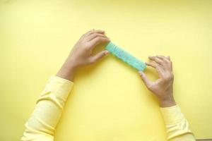 man's hands taking medicine from a pill box on yellow background photo