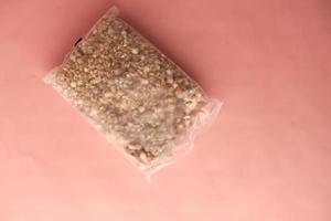 Home Made Musli in a plastic packet on pink photo