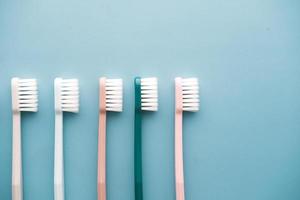 colorful toothbrushes on light green background with copy space photo